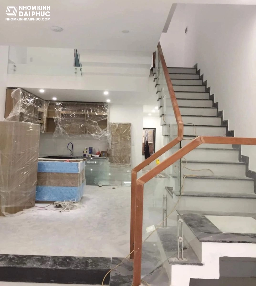 Cầu thang kính cường lực tay vịn gỗ